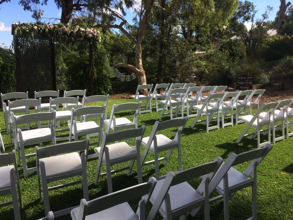 White americana chairs on grass paddock.