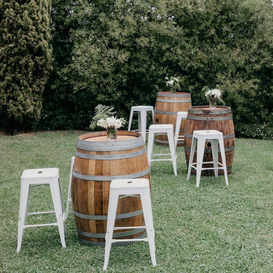 Wine Barrels and white stools on grass.